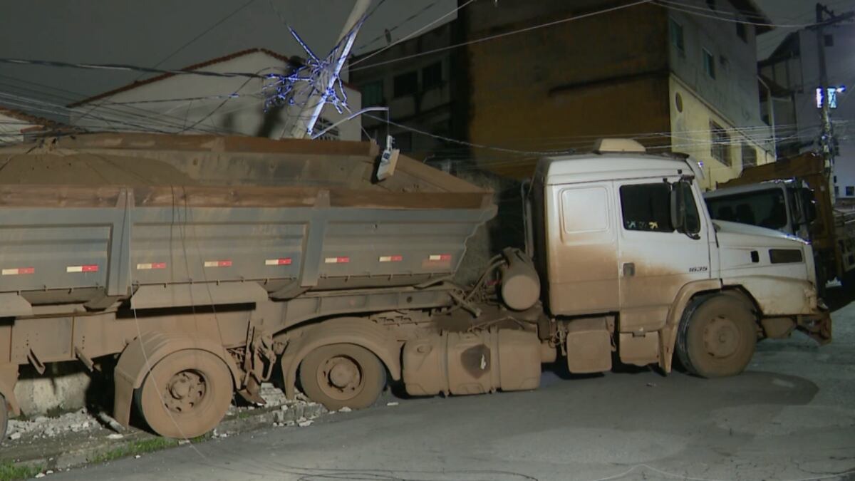 Caminhão carregado de minério volta de ré em rua íngreme de Sabará (MG), atinge poste e bate em casa