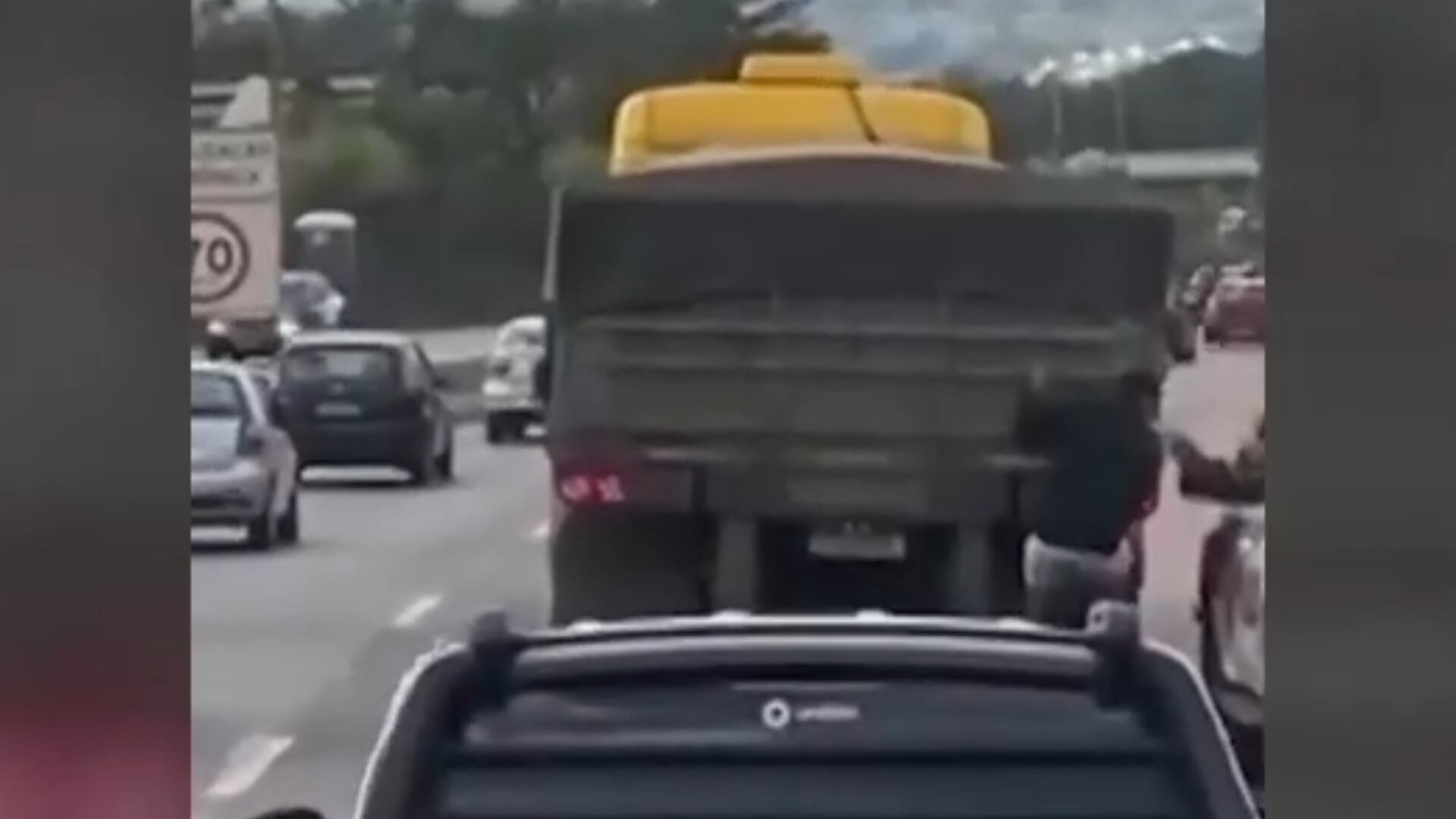 Policial derruba homem pendurado em caminhão em movimento