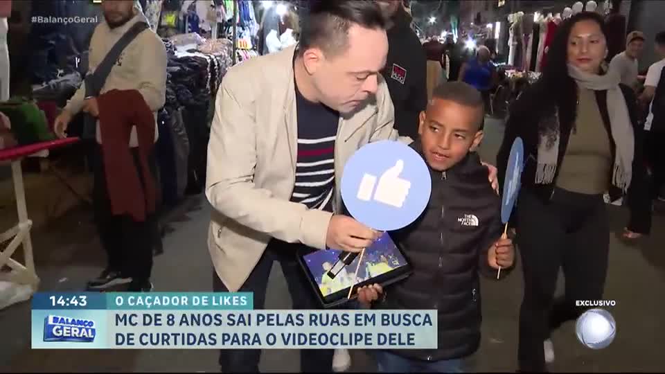 Menino de 8 anos faz sucesso na internet com música e pede 'likes' nas ruas de SP
