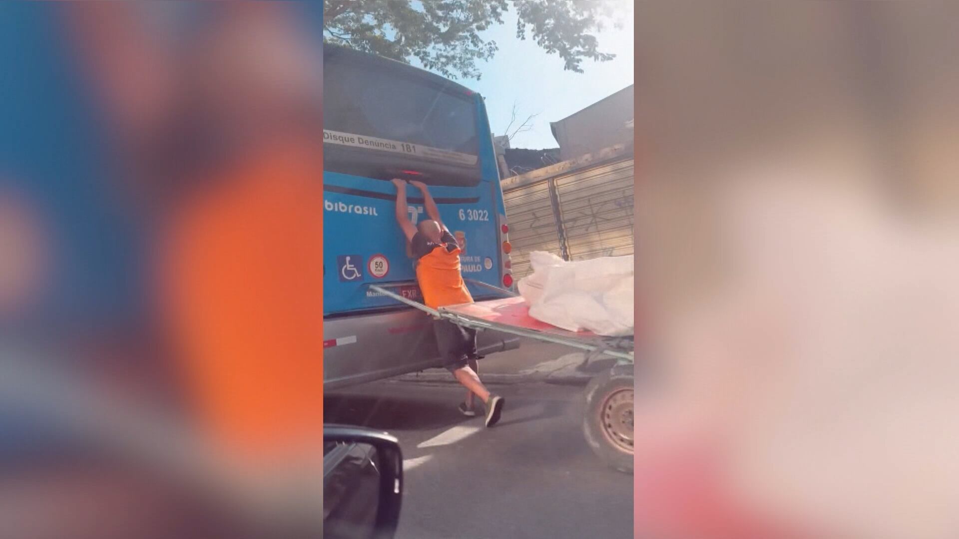 Coletor de recicláveis é flagrado pegando carona em ônibus em avenida de SP