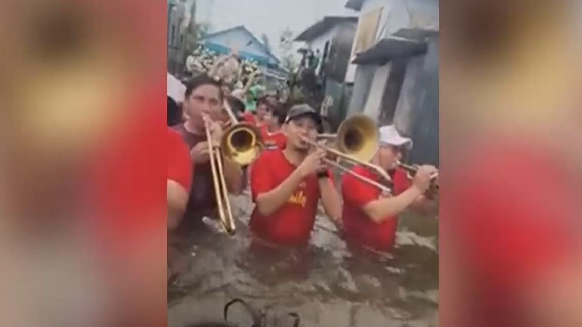 Músicos atravessam ruas alagadas para seguir com apresentação