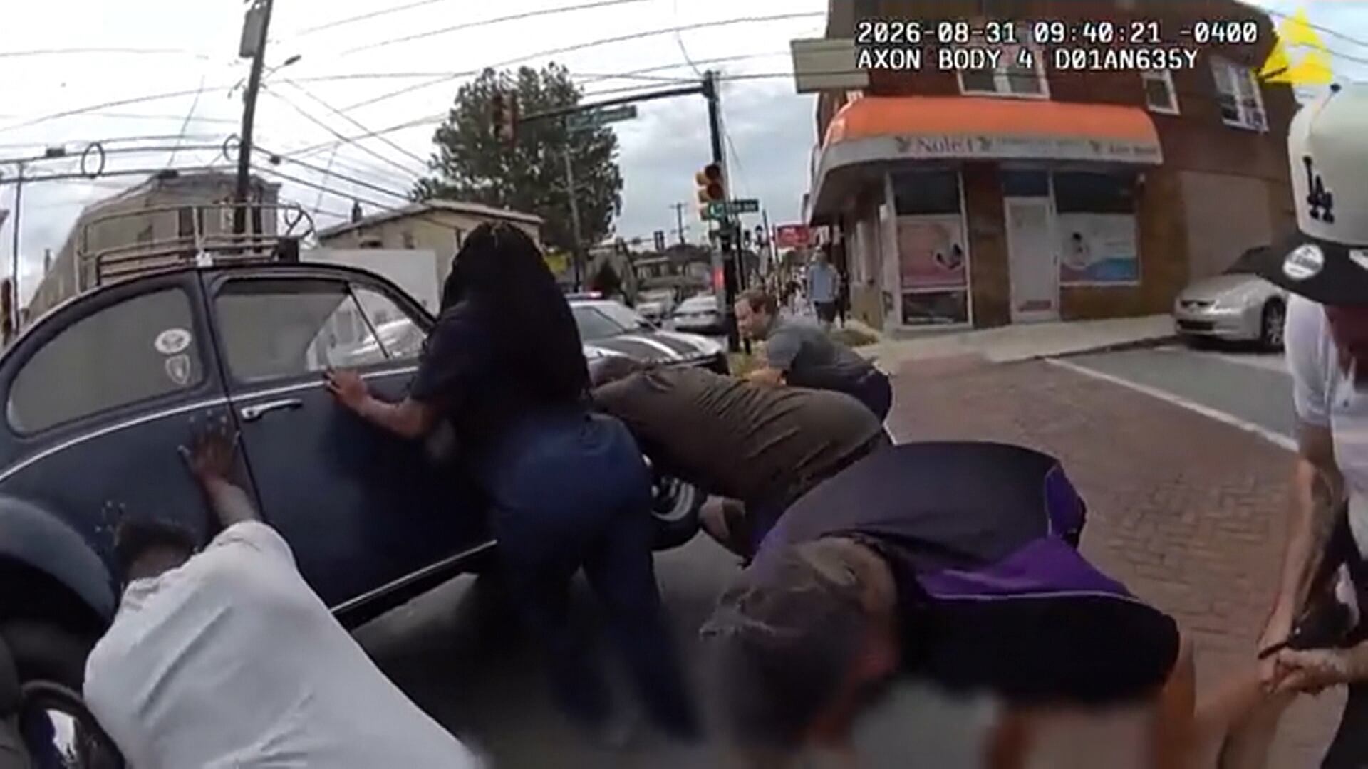 Grupo de mobiliza para levantar carro e retirar ciclista que ficou presa após acidente
