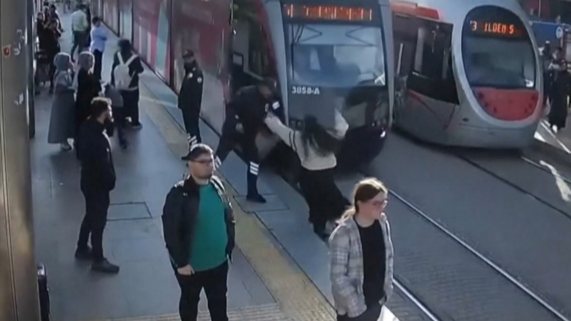 Mulher não vê trem se aproximar e é salva por um triz